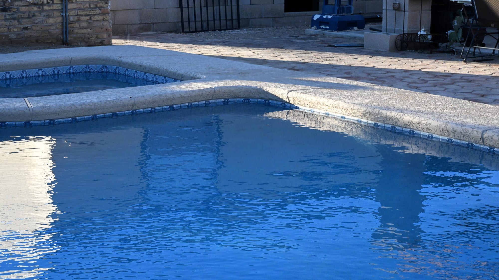 Pool and spa with natural stone decking in a Rita Ranch backyard by Sorce Signature Outdoors