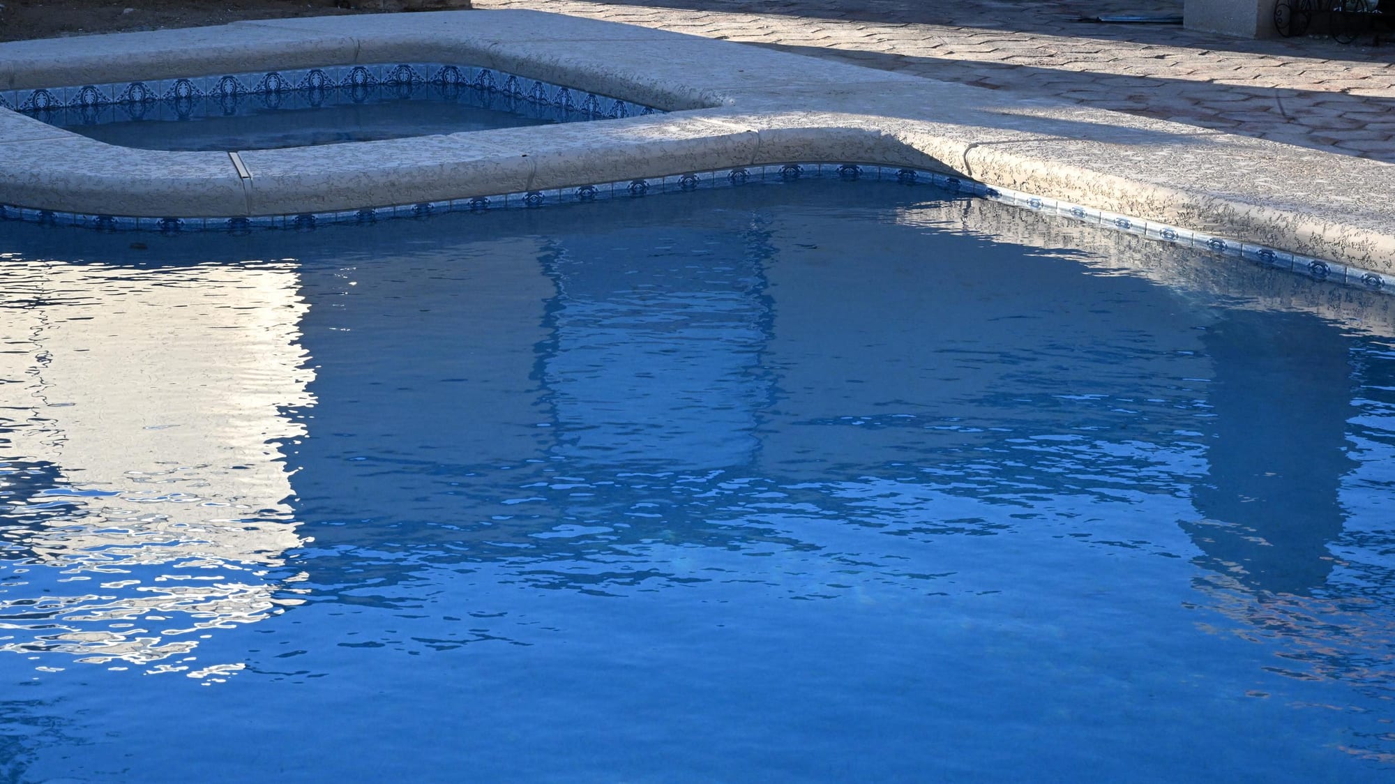 Custom pool with curved concrete edge and desert backyard in Vail by Sorce Signature Outdoors