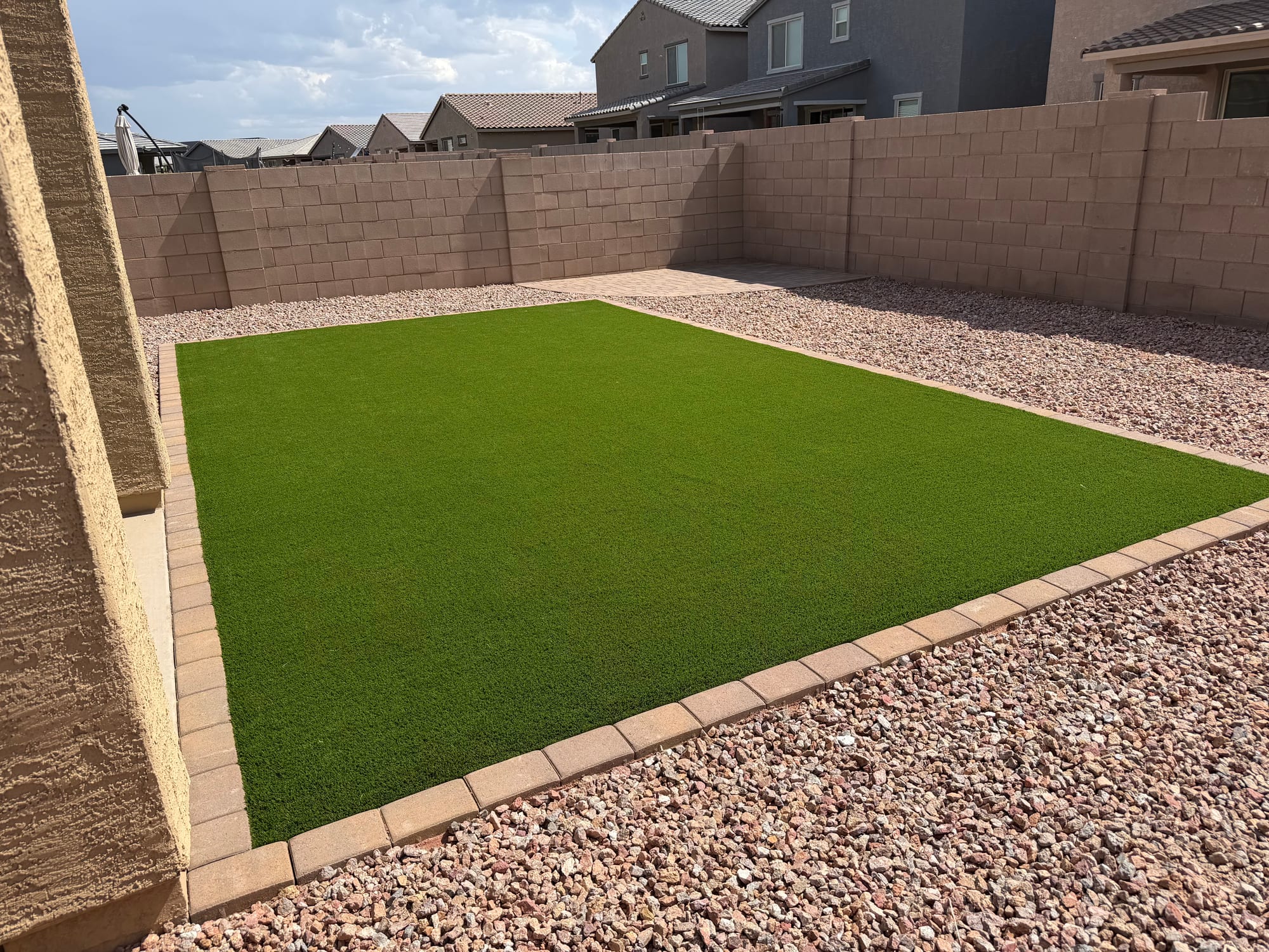 A low-water yard combining artificial turf and decorative gravel in Tucson by Sorce Signature Outdoors