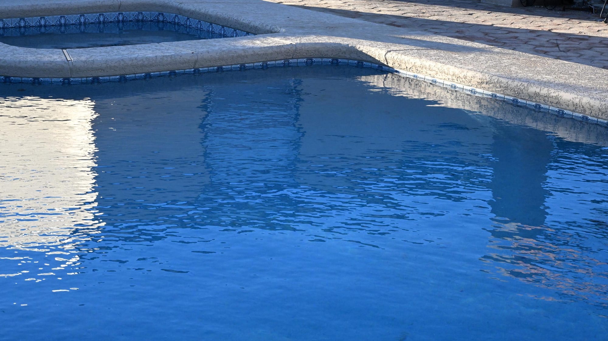 Custom pool with raised spa and concrete decking in a Sahuarita backyard by Sorce Signature Outdoors